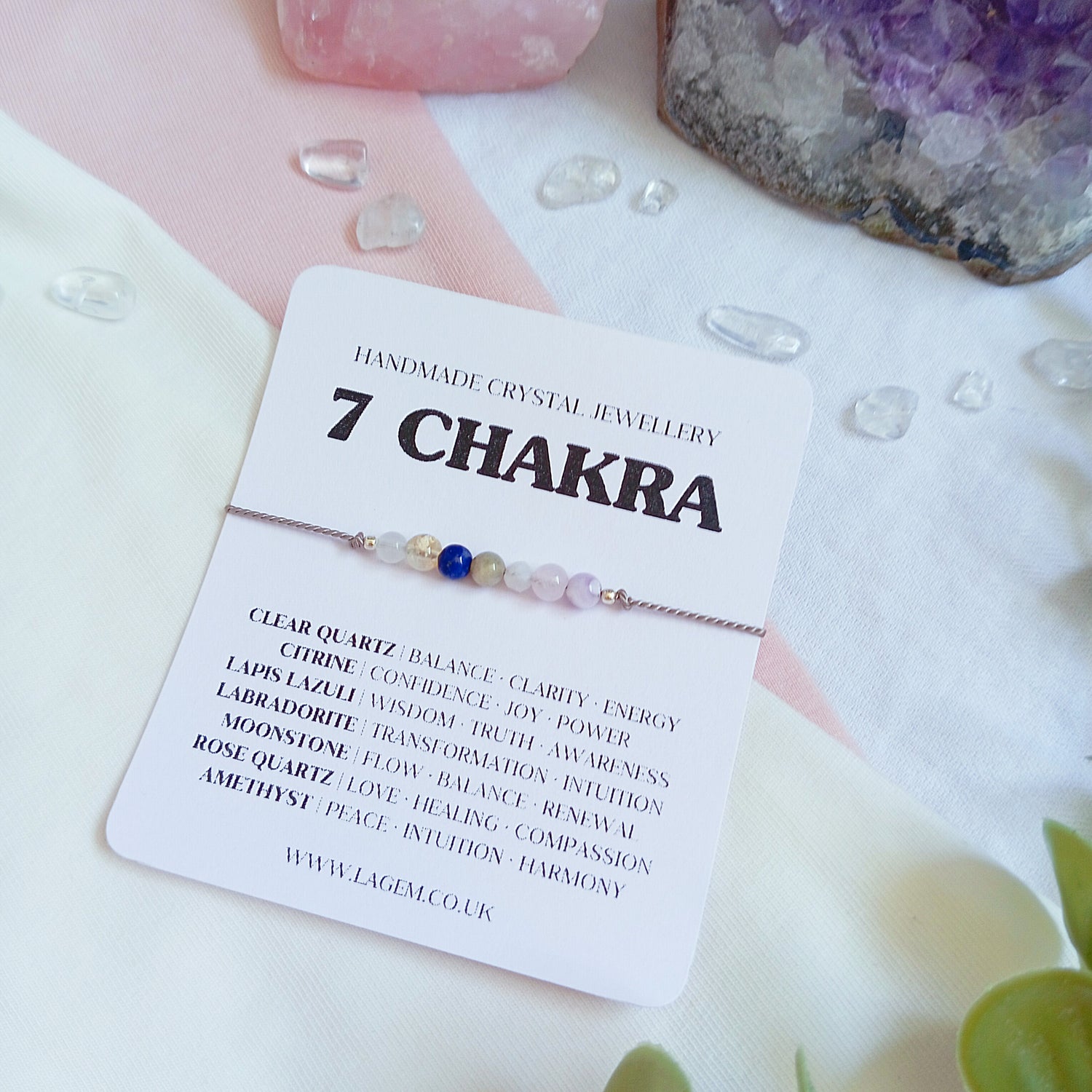 7 Chakra bracelet on a card with crystals and stones in the background